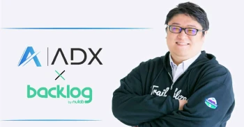 株式会社 ADX Consultingの担当者と、株式会社 ADX ConsultingとBacklogのロゴが写っている写真