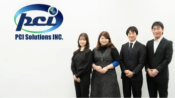 PCIソリューションズ株式会社の担当者4名とロゴが写っている写真